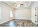 Bedroom with wood floors, tray ceiling, fan, and entrance to door at 1106 Bakary Ct, Decatur, GA 30032