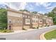 Row of townhomes with brick and siding, garages, and landscaped front yards at 1106 Bakary Ct, Decatur, GA 30032