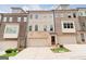 View of townhome exteriors with brick and vinyl siding and attached garages, offering curb appeal and convenient parking at 1106 Bakary Ct, Decatur, GA 30032