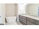 Luxurious primary bathroom with a standalone tub, granite counters, and gray cabinets at 1106 Bakary Ct, Decatur, GA 30032