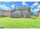 Expansive backyard with a gray siding on the house, bright green lawn and tall trees at 1370 Sunnys Halo Dr, Suwanee, GA 30024