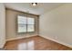 An empty bedroom has hardwood floors, a large window and neutral walls at 1370 Sunnys Halo Dr, Suwanee, GA 30024