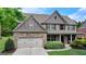 Charming two-story brick home with a two-car garage and manicured front yard at 1370 Sunnys Halo Dr, Suwanee, GA 30024