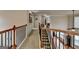 Upstairs hallway with carpet, wood railing, and a view of the living room at 1370 Sunnys Halo Dr, Suwanee, GA 30024