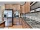 Kitchen with stainless steel appliances, gas range, granite counters, and wood cabinets at 1370 Sunnys Halo Dr, Suwanee, GA 30024