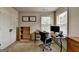 Bright home office features neutral walls, two windows, and practical furniture at 1370 Sunnys Halo Dr, Suwanee, GA 30024