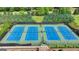 Aerial of four well-maintained tennis courts for community enjoyment, surrounded by greenery at 1370 Sunnys Halo Dr, Suwanee, GA 30024