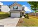 Inviting home features a two-car garage, landscaped front yard and welcoming entrance at 1003 Nandina Ct, Villa Rica, GA 30180