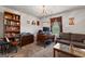 Office space with a dark brown sofa, wooden desk and bookcase, and a chandelier at 1003 Nandina Ct, Villa Rica, GA 30180
