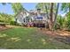Charming backyard view showcasing a well-maintained lawn, mature trees, and a cozy deck area at 229 Terrane Rdg, Peachtree City, GA 30269