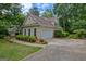 Traditional-style home featuring a two-car garage, manicured landscaping, and a mature tree line at 229 Terrane Rdg, Peachtree City, GA 30269