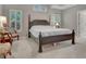 Comfortable main bedroom with a dark wood bed frame, carpeted floors, and bright natural light at 229 Terrane Rdg, Peachtree City, GA 30269