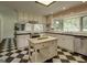 Updated kitchen with checkerboard tile flooring and stainless appliances at 2942 Old Norcross Rd, Tucker, GA 30084