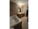 Bathroom with jetted tub, tile surround, double vanity with wood cabinets and tile flooring at 220 Jackson Rd, Mcdonough, GA 30252