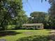 A quaint single-story home features a well-maintained yard with mature trees at 220 Jackson Rd, Mcdonough, GA 30252