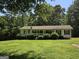 Charming home featuring a covered porch, a well-manicured lawn, and lovely landscaping at 220 Jackson Rd, Mcdonough, GA 30252