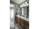 This full bathroom features a double sink vanity, ceramic tile flooring, and a shower tub combo at 9742 Fallview Ct, Villa Rica, GA 30180