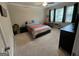 Spacious carpeted bedroom with ceiling fan, two windows, desk, and colorful bedspread at 3608 Davenport Rd, Duluth, GA 30096