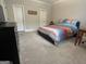 Carpeted bedroom featuring neutral walls, crown molding, two entry doors, and a cozy, colorful bed at 3608 Davenport Rd, Duluth, GA 30096