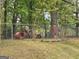 Chain-link fence surrounding a backyard with assorted playground equipment and debris at 957 Astor Ave, Forest Park, GA 30297