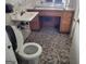 Bathroom featuring dark mosaic tile floor, toilet and sink with vintage cabinets at 957 Astor Ave, Forest Park, GA 30297
