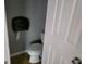 Small bathroom featuring a toilet and wall-mounted paper towel dispenser at 957 Astor Ave, Forest Park, GA 30297