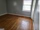 This bedroom features hardwood flooring and natural light from the window at 957 Astor Ave, Forest Park, GA 30297