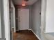 Hallway with light gray walls and a white door featuring an illuminated exit sign at 957 Astor Ave, Forest Park, GA 30297