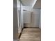 Hallway with laminated wood flooring and white-painted walls, with closet at 957 Astor Ave, Forest Park, GA 30297