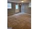Empty room featuring tile floors, grey walls, and a window with white blinds and a door with glass and an exit sign above it at 957 Astor Ave, Forest Park, GA 30297