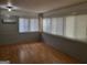 Bright sunroom featuring multiple windows with blinds, light fixture, and hardwood flooring at 957 Astor Ave, Forest Park, GA 30297