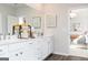 Bright bathroom featuring double sinks, white cabinets, and a view to the bedroom at 602 Belshire Dr, Acworth, GA 30102