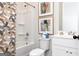 Well-lit bathroom features a shower-tub combo with attractive shower curtain and modern sink with framed artwork at 602 Belshire Dr, Acworth, GA 30102