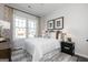 Comfortable bedroom featuring a large window, decorative curtains, stylish lamps, and contemporary decor at 602 Belshire Dr, Acworth, GA 30102