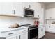 Well-appointed kitchen boasts white cabinetry, stainless steel appliances, and sleek countertops and tiled backsplash at 602 Belshire Dr, Acworth, GA 30102