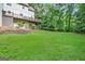 Expansive backyard with a lush green lawn and a deck perfect for outdoor entertaining and overlooking mature trees at 1214 Weatherstone Way, Peachtree City, GA 30269