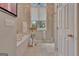 Well-lit bathroom with a tub, shower, and a large window with a view at 1214 Weatherstone Way, Peachtree City, GA 30269
