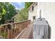 Long, spacious wooden deck with wood railing, a barbeque and partial view of the yard at 1214 Weatherstone Way, Peachtree City, GA 30269
