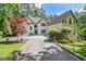 Elegant two-story home features a long driveway, manicured lawn, and mature trees for privacy at 1214 Weatherstone Way, Peachtree City, GA 30269
