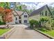 Attractive two-story home showcases a sprawling driveway, verdant landscaping, and established trees at 1214 Weatherstone Way, Peachtree City, GA 30269