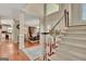Spacious foyer with hardwood floors, showcasing the staircase and the dining room beyond the decorative pillars at 1214 Weatherstone Way, Peachtree City, GA 30269