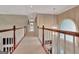 Hallway with chandelier and view overlooking the staircase below at 1214 Weatherstone Way, Peachtree City, GA 30269