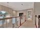 Bright hallway with chandelier lighting, wood railing and door to the bathroom at 1214 Weatherstone Way, Peachtree City, GA 30269
