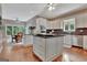 Open-concept kitchen with a large island, stainless steel appliances, and hardwood floors at 1214 Weatherstone Way, Peachtree City, GA 30269