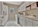 Functional laundry room featuring white cabinets, sink, and modern appliances at 1214 Weatherstone Way, Peachtree City, GA 30269
