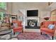 Comfortable living room featuring a fireplace, large windows, and stylish seating, creating a relaxing space at 1214 Weatherstone Way, Peachtree City, GA 30269