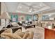 Open living room featuring large windows, tray ceiling, plush seating, and an elegant rug at 1214 Weatherstone Way, Peachtree City, GA 30269