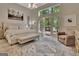 Elegant main bedroom with a tufted headboard, bench, balcony, and natural light at 1214 Weatherstone Way, Peachtree City, GA 30269