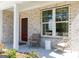 Cozy front porch with brick accents, a red door, and a charming seating arrangement at 608 Belshire Dr, Acworth, GA 30102