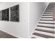 Hallway featuring modern wall art and stairs with dark wood and white risers at 608 Belshire Dr, Acworth, GA 30102